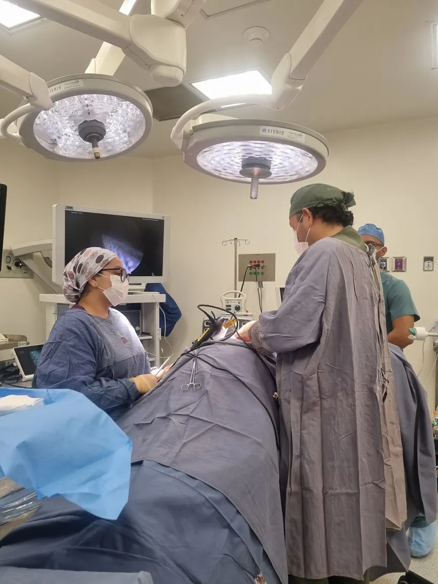 Sala de procedimientos durante una pleuroscopia: el médico introduce el pleuroscopio en el costado del paciente, cubierto con campos estériles, mientras la imagen se ve en el monitor